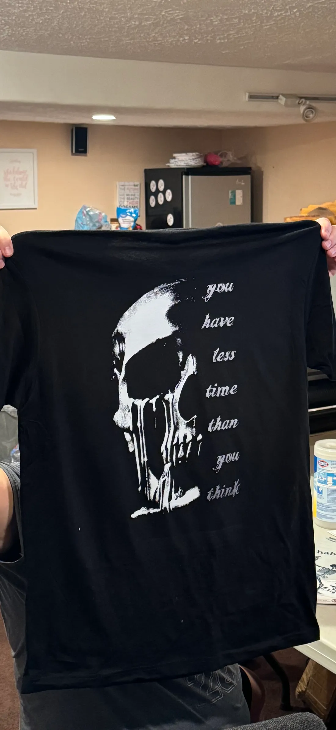 Black tee with a white skull print reading 'you have less time than you think'