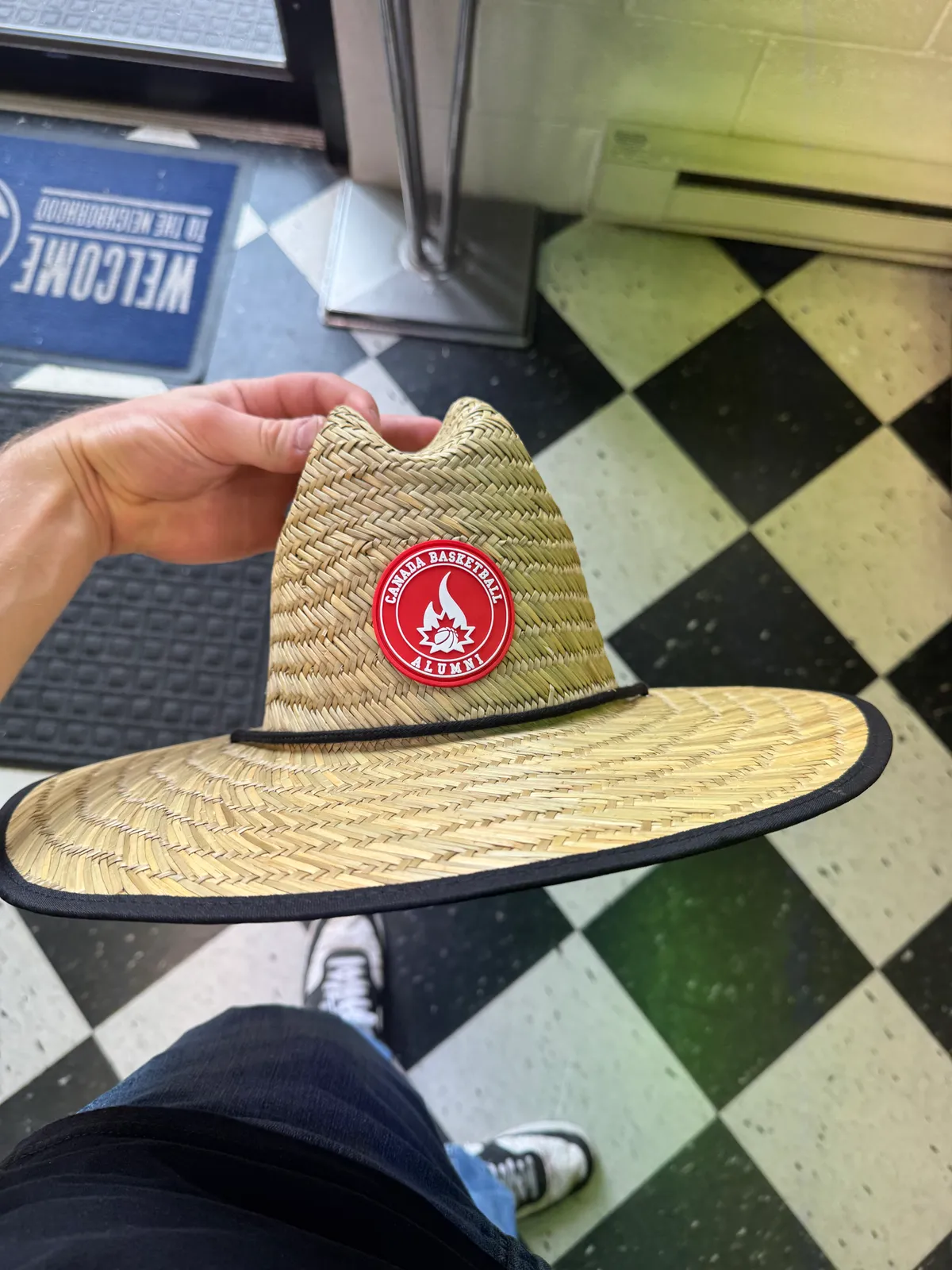 Wide-brim straw lifeguard hat with a round red Canada Basketball Alumni rubber patch