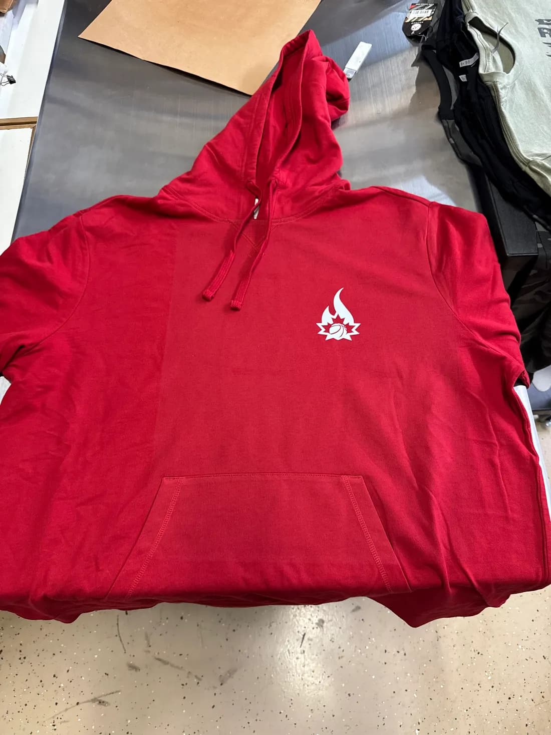 Red pullover hoodie with a white one-color left-chest print for a Canada Olympic basketball alumni group
