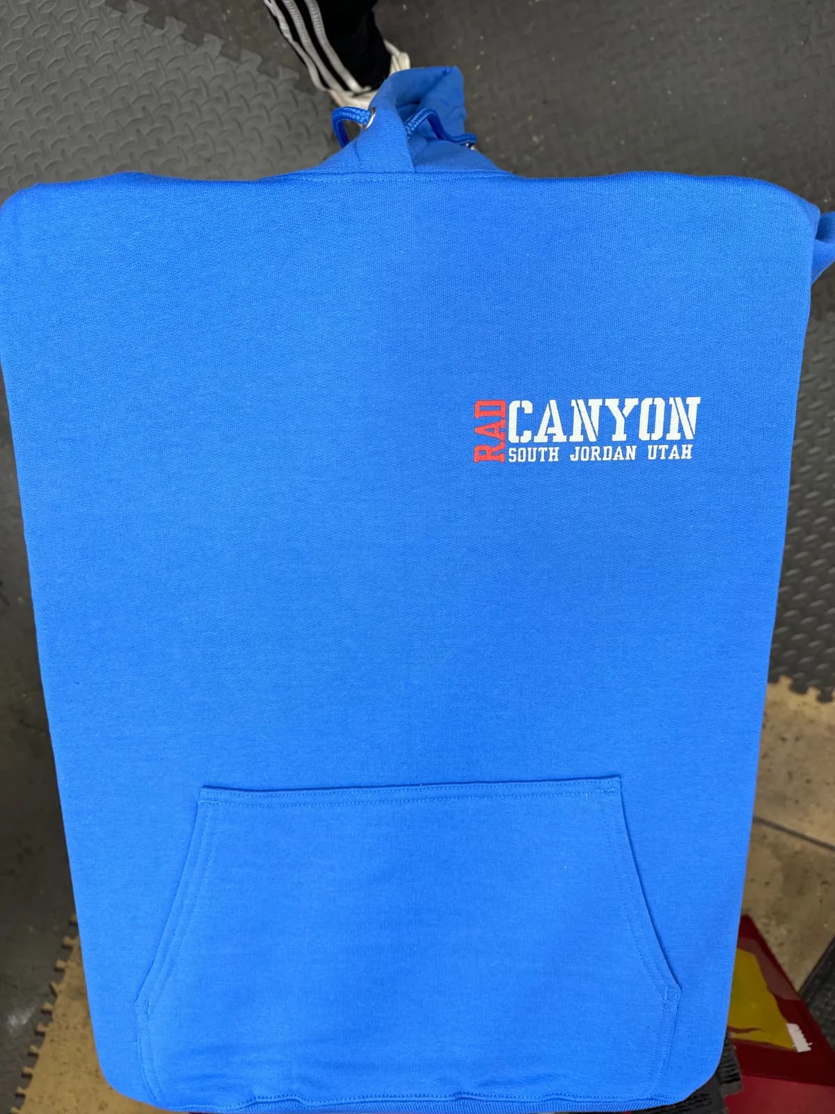 Bright blue hoodie with a white and red Rad Canyon South Jordan Utah left-chest print
