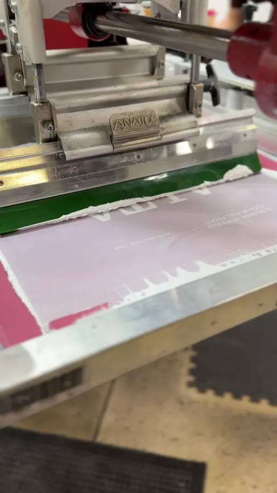 Alta High School design on the screen printing press at Koala-Tees