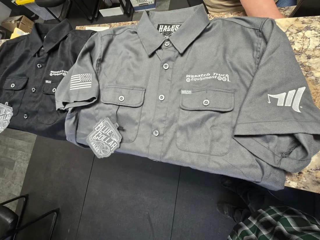 Embroidered Wasatch Truck Equipment work shirts with an American flag sleeve patch, stitched by Koala-Tees